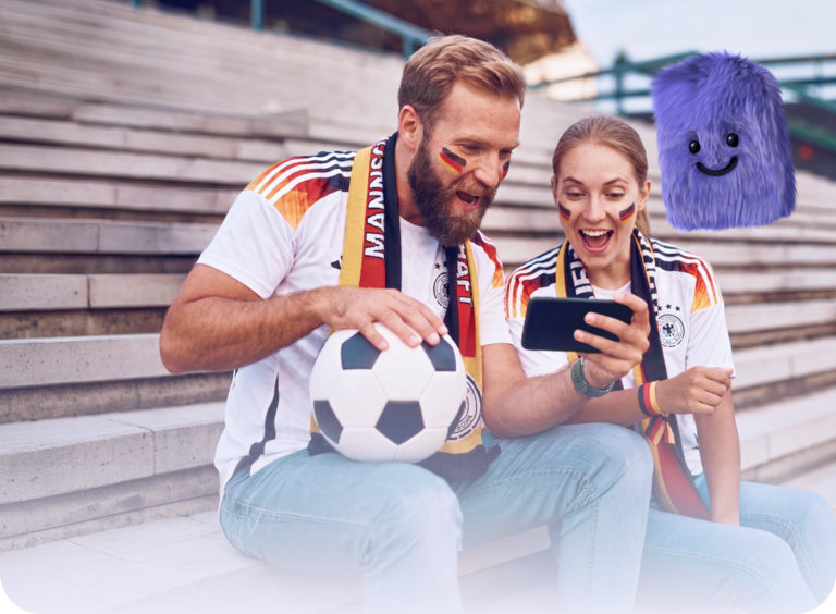 WM-Handytarif Aktion | Zwei Fußballfans schauen auf dem Handy die WM-Fußballergebnisse an.