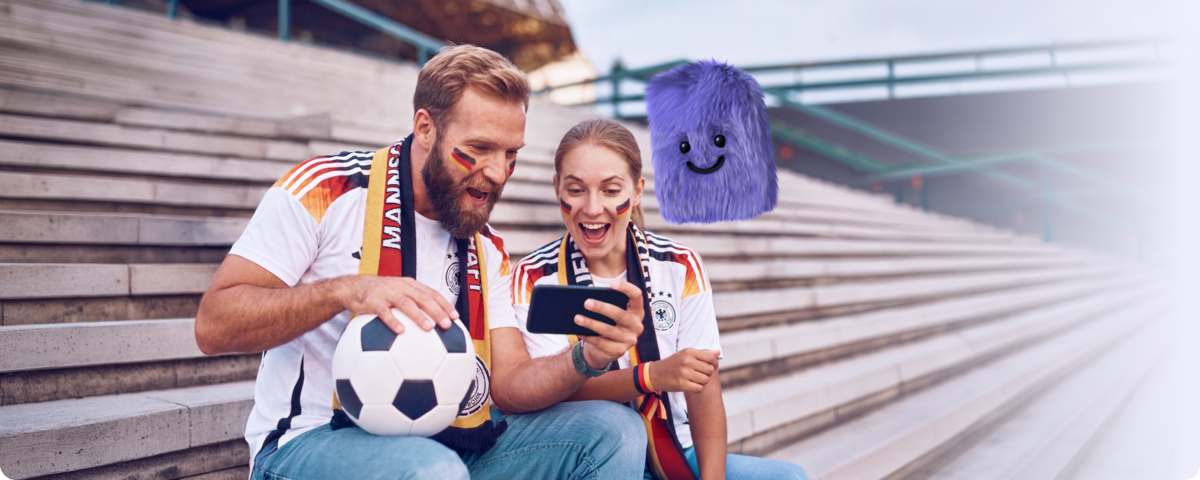 WM-Handytarif Aktion | Zwei Fußballfans schauen auf dem Handy die WM-Fußballergebnisse an.