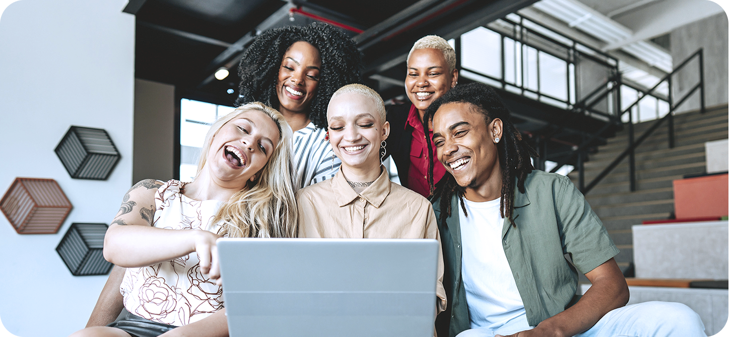 Bild zeigt eine Gruppe Freunde vor einem Laptop