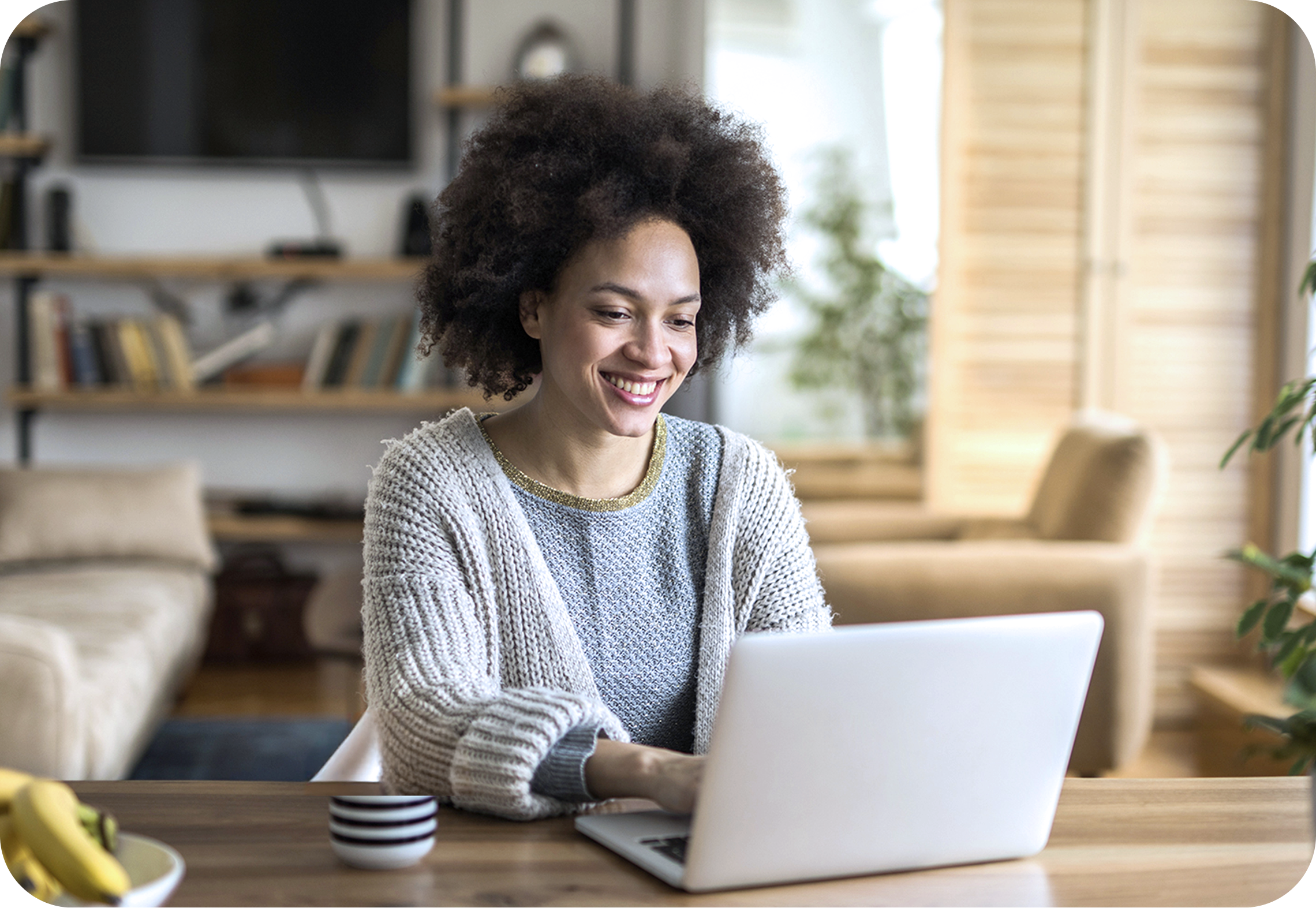 Frau mit Laptop sitzt am Tisch und nutzt BIGSIM DSL