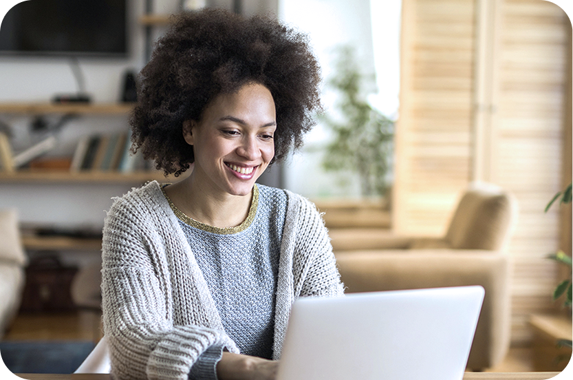 Frau mit Laptop sitzt am Tisch und nutzt BIGSIM DSL