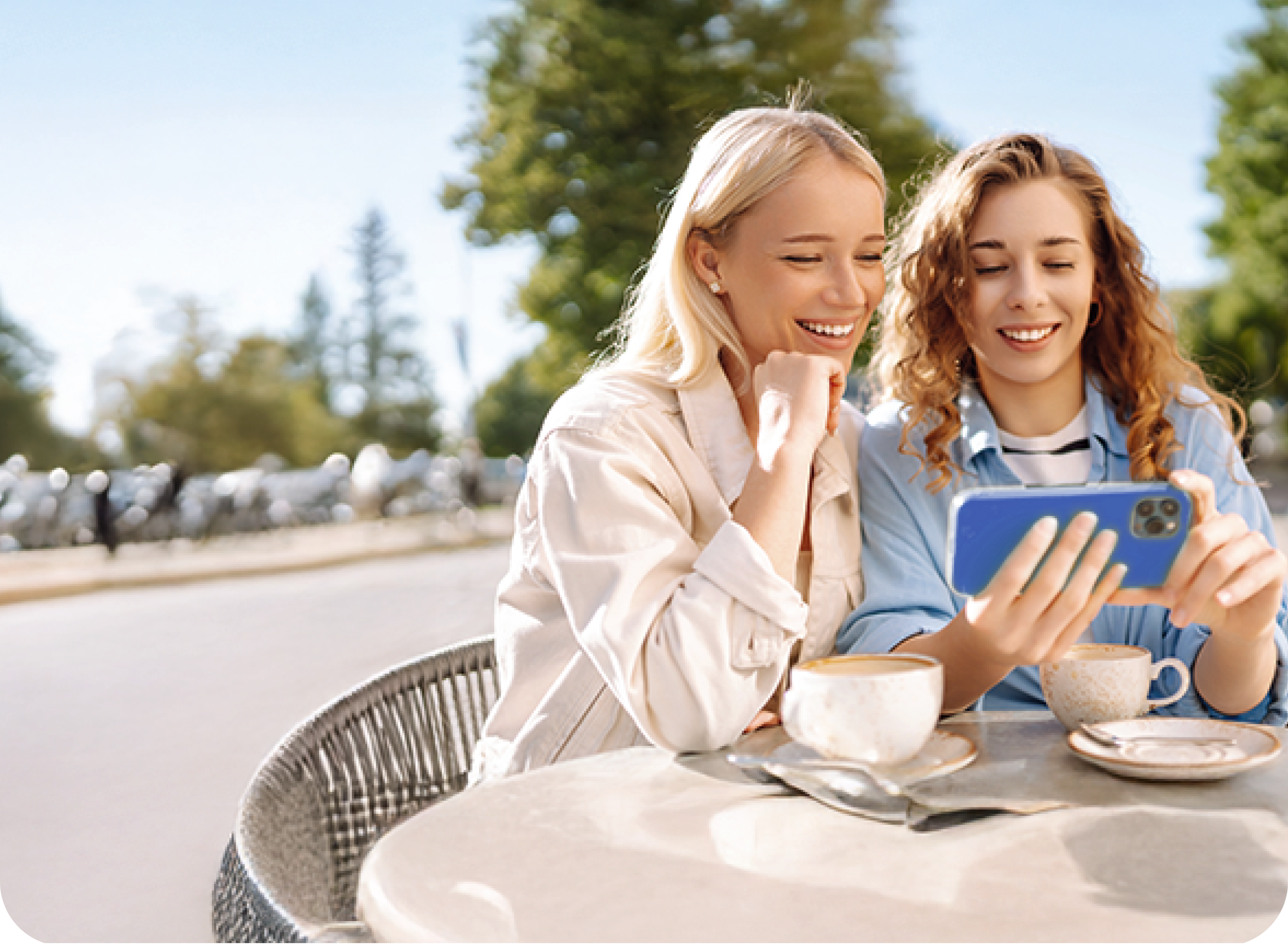 Zwei junge Frauen sitzen im Café und nutzen die günstigen Handytarife ohne Handy von BIGSIM.